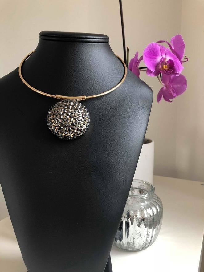 Halsband med gyllene band med runda hänge och svarta stenar