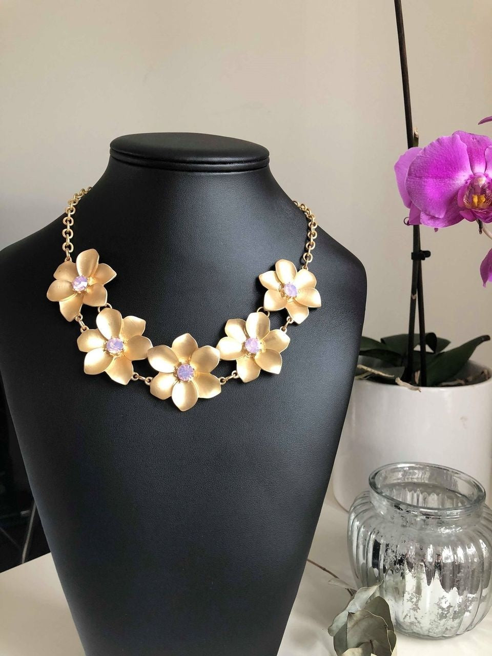 Gyllene halsband med blommor och rosa stenar